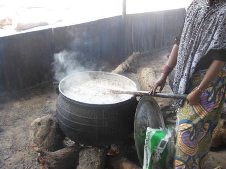 A cook mixing food on fire at Dalori Camp
